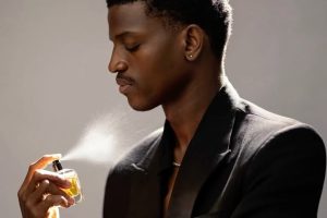 Black man applying deodorant and perfume getting ready