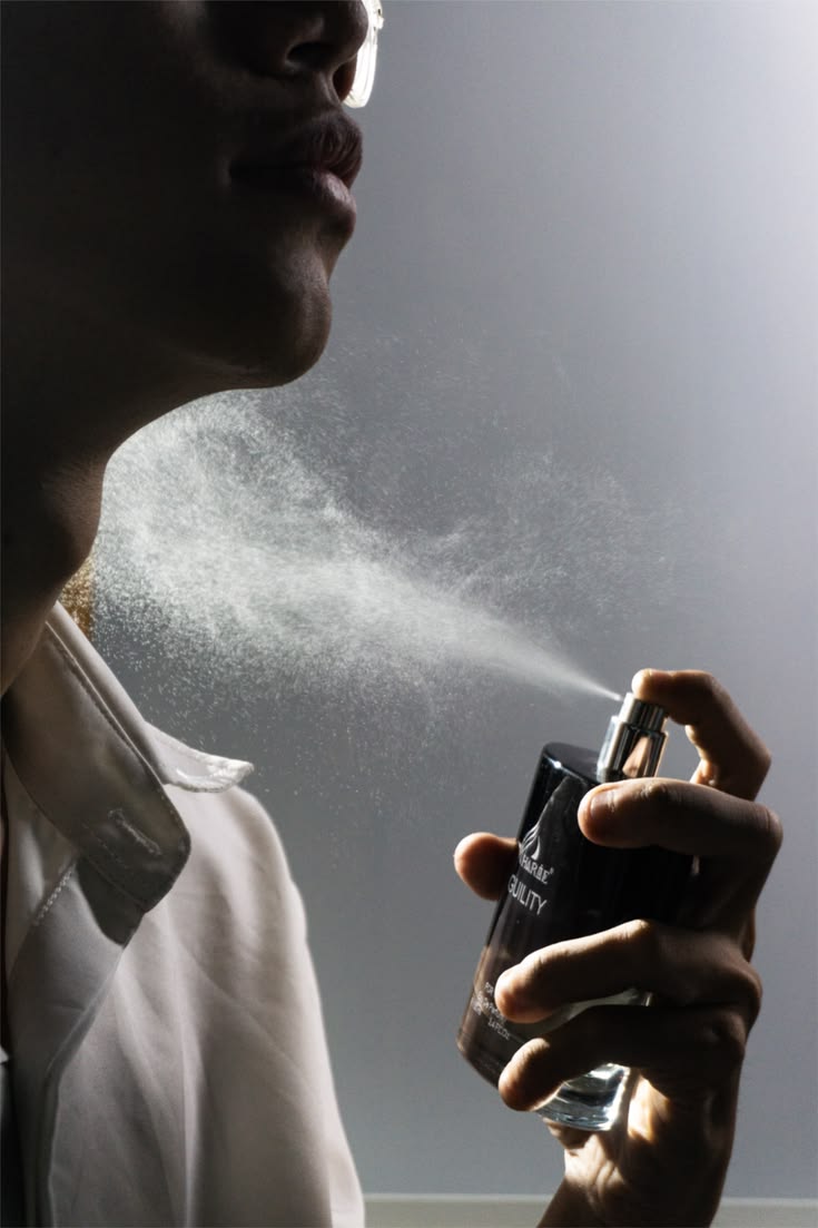 Black man applying deodorant and perfume getting ready