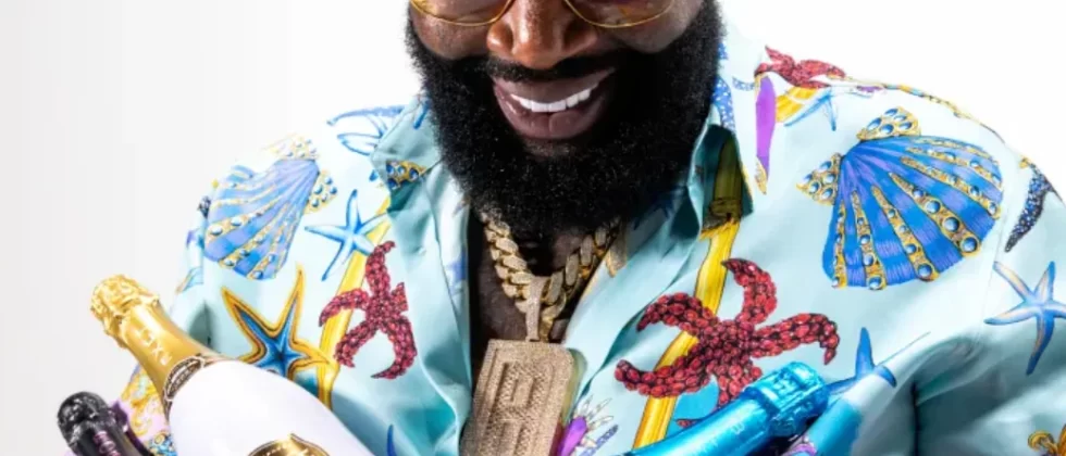 Rick Ross holding a Belaire bottle and Rick Ross speaks about Tanzania and his big ideas with Paul Makonda